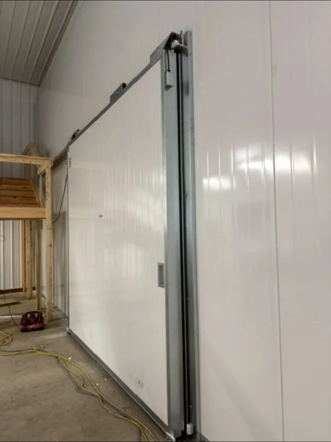 Horizontal sliding freezer door and overhead track